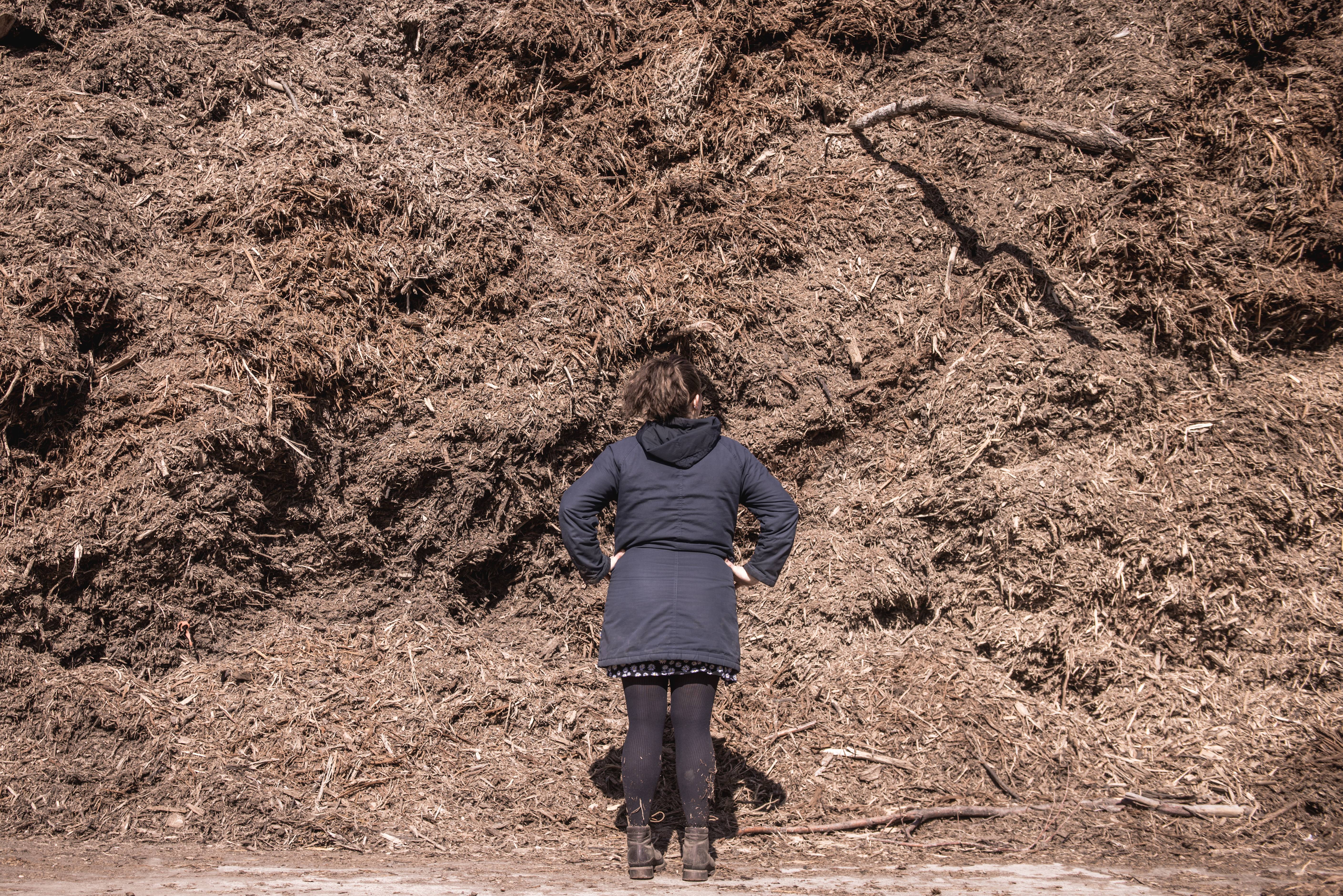 Hillside Solutions_Gill standing in front of large mulch pilee.jpg